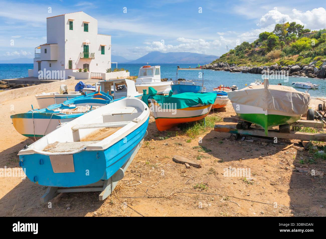 Ruderboote am Sandstrand von Sant'Elia, Santa Flavia, mit einem weißen Haus am Meer, in der Nähe von Palermo, Sizilien, Italien Stockfoto