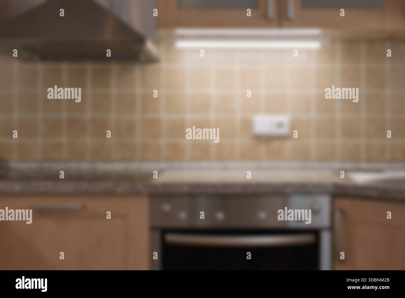 Klassische Küche mit verschwommenem Interieur. Braune Fliesen, Backofen und Dunstabzugshaube. Stockfoto