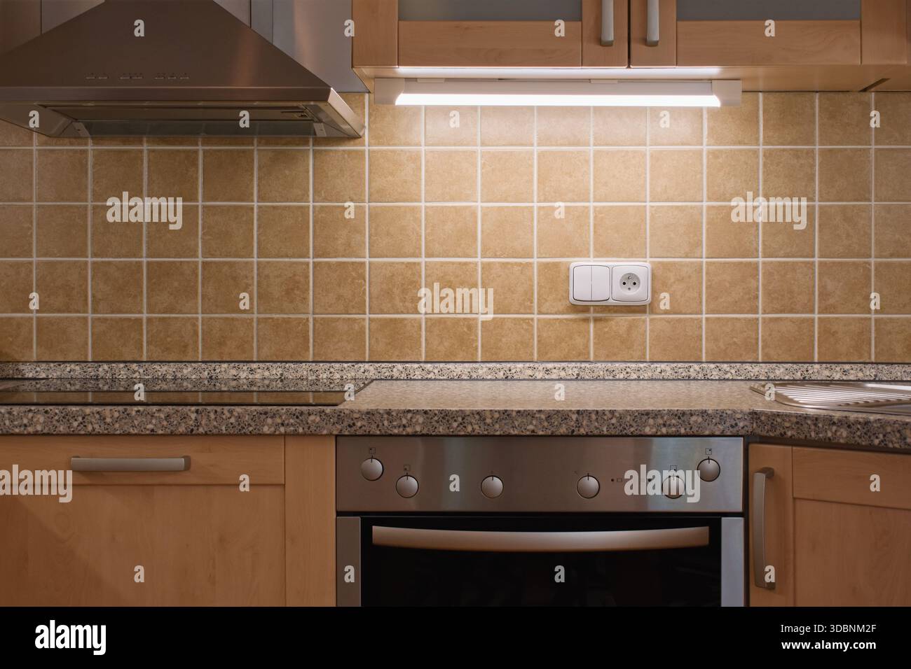 Klassische Küche. Braune Fliesen, Backofen und Dunstabzugshaube. Stockfoto