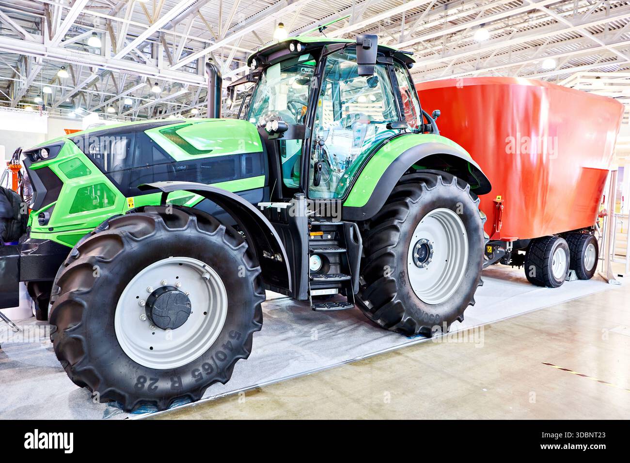 Agrar-Industrietraktor mit gezogenem Mischer für die Fütterung von Tieren auf dem Bauernhof Stockfoto