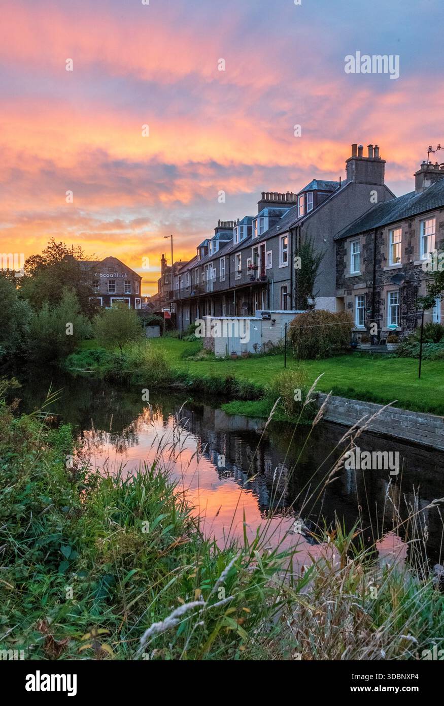 Die Stadt Cuddy Peebles ist in warmen Farben, einem ruhigen Kanal und grünen Gärten eingetaucht. Stockfoto