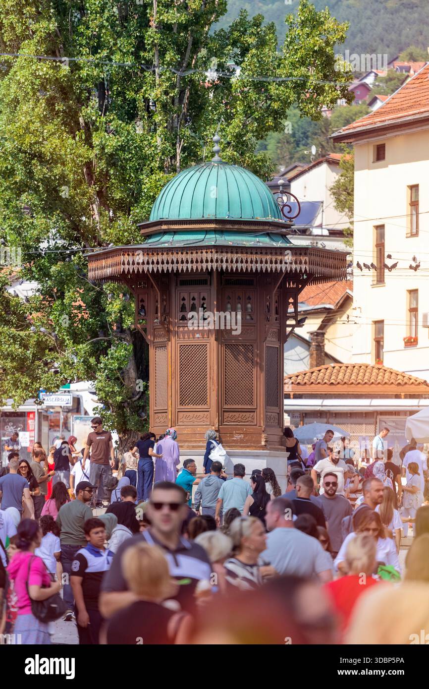Der berühmte Sebilj-Brunnen in Bascarsija, Sarajevos historischem osmanischen Basar, steht als Symbol des kulturellen Erbes der Stadt, umgeben von Massen von Einheimischen und Besuchern an einem lebhaften Sommertag in Sarajevo, Bosnien und Herzegowina Stockfoto