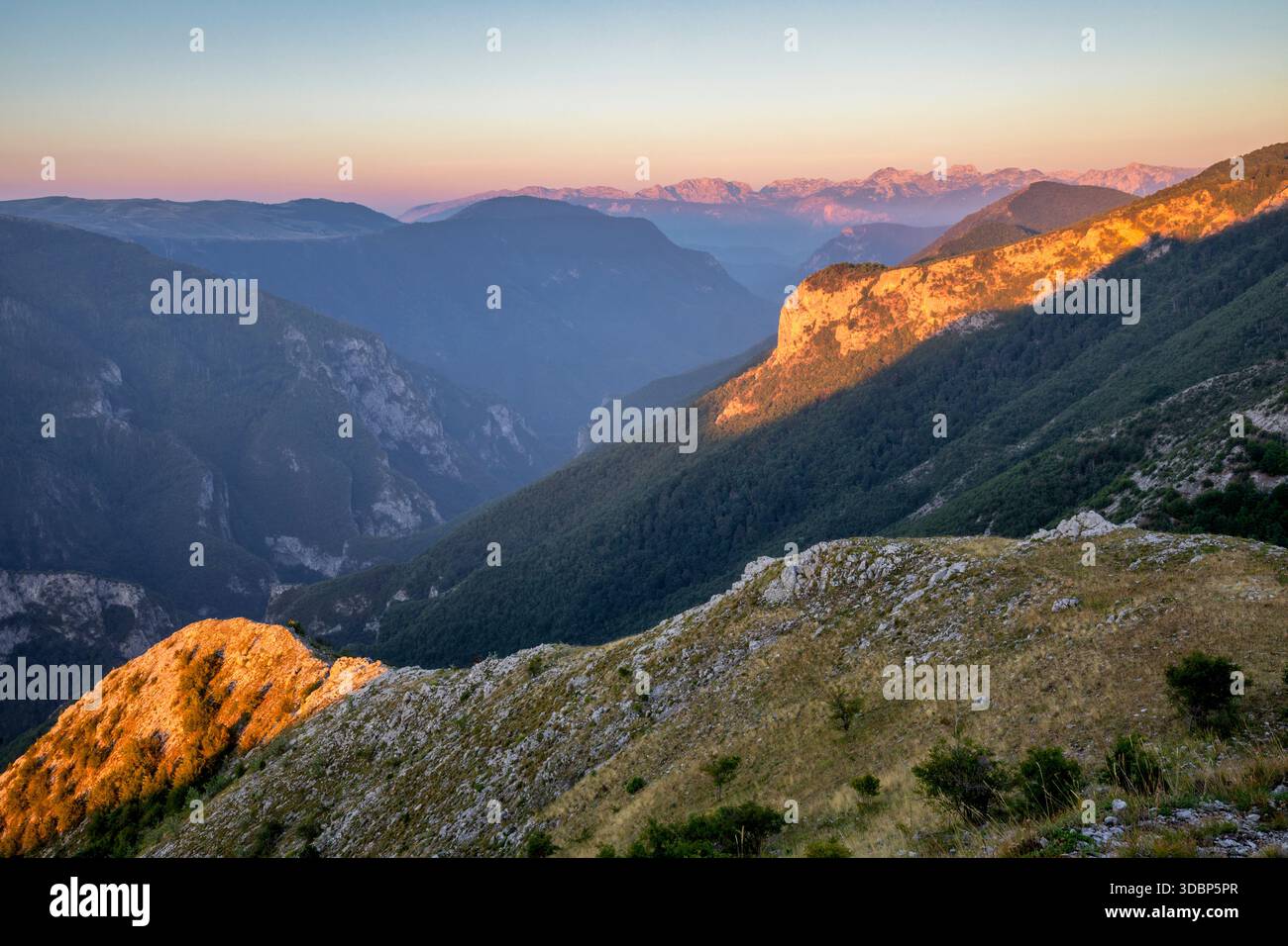 Das erste Licht der Dämmerung färbt die Klippen des Rakitnica Canyon mit goldenen Tönen, während sich die Berge endlos bis in den Horizont erstrecken. Lukomir, Konjic, Kanton Herzegowina-Neretva, Bosnien und Herzegowina Stockfoto