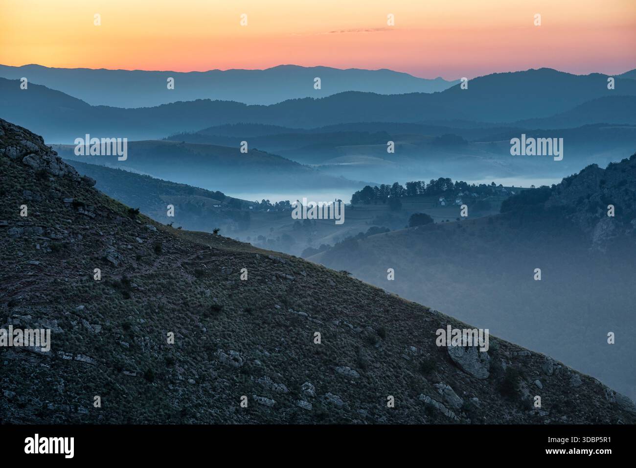 Ein ruhiger Blick von Lukomir kurz vor Sonnenaufgang, mit nebeligen Tälern und überlagerten Hügeln, die im sanften Licht der Dämmerung in die Ferne fallen. Lukomir, Konjic, Kanton Herzegowina-Neretva, Bosnien und Herzegowina Stockfoto