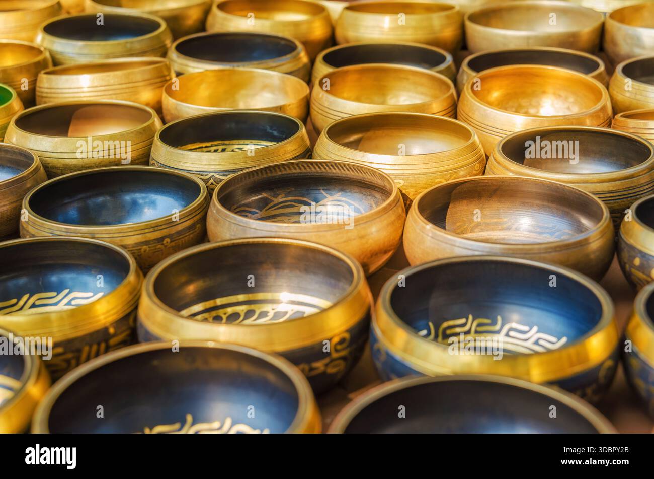 Eine ordentlich arrangierte Sammlung tibetischer Singglocken aus Metall, die auf einem Markt in Kathmandu, Nepal, verkauft werden Stockfoto