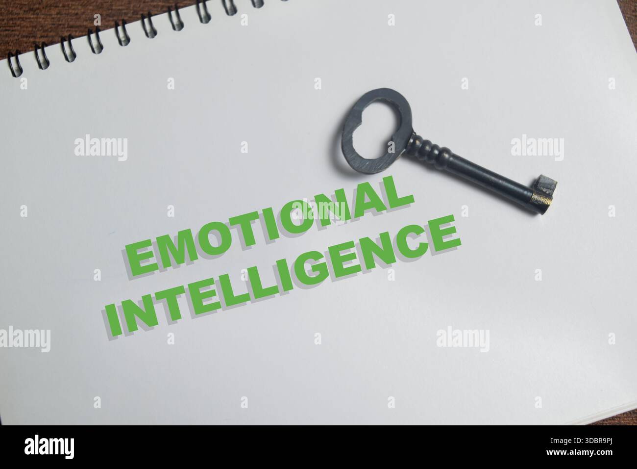 Das Konzept der emotionalen Intelligenz schreibt auf Buch isoliert auf Holztisch. Stockfoto