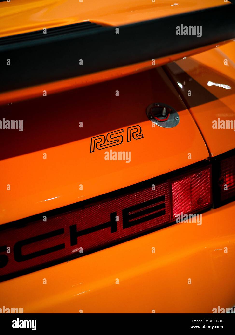 Heckdetail eines orangen Porsche 911 RSR Langstrecken-Rennwagens mit RSR-Emblem, Heckflügel und markantem Motorsport-Design. Stockfoto