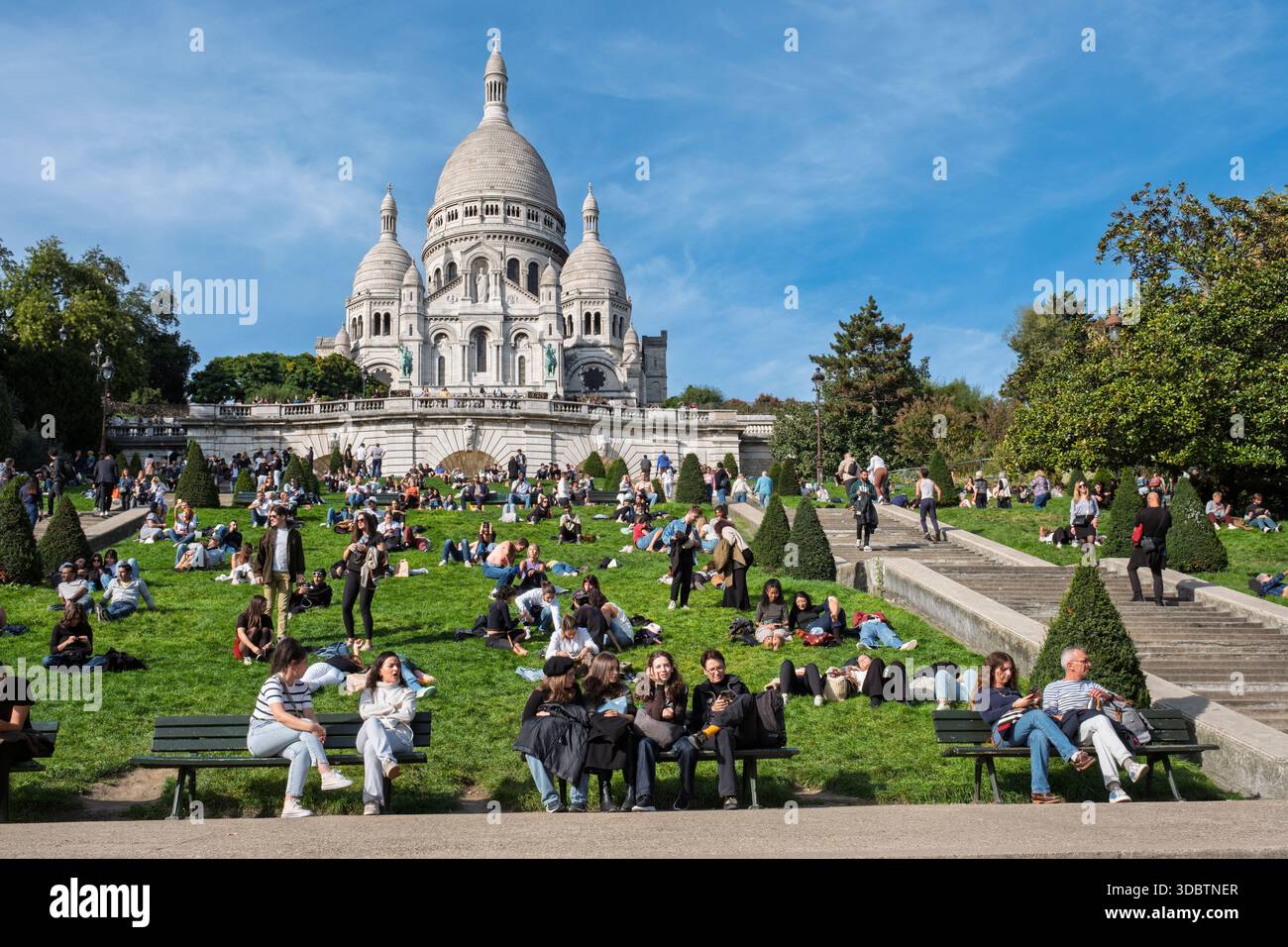 Menschen auf dem Hügel von Montmartre an einem Sonntagnachmittag unter der Basilika Sacre-Coeur, Paris, Frankreich Stockfoto