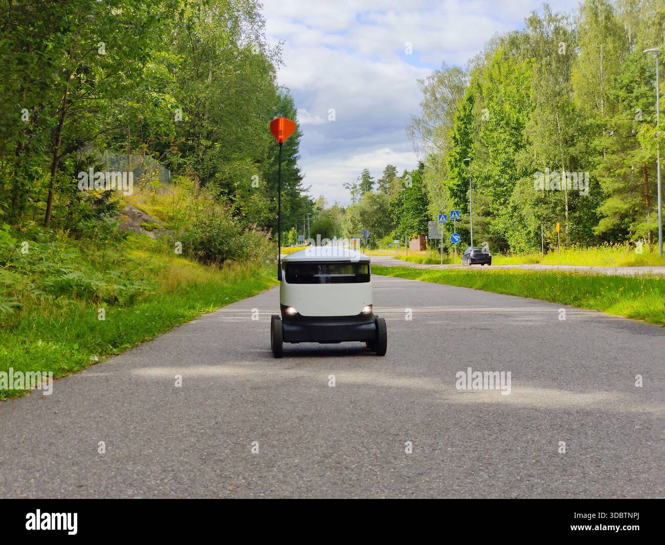 Lieferroboter, der auf einem Bürgersteig in Espoo, Finnland, arbeitet. Sechrädriger, emissionsfreier Roboter, der für die letzte Meile von Lebensmitteln und Lebensmittellieferungen verwendet wird Stockfoto