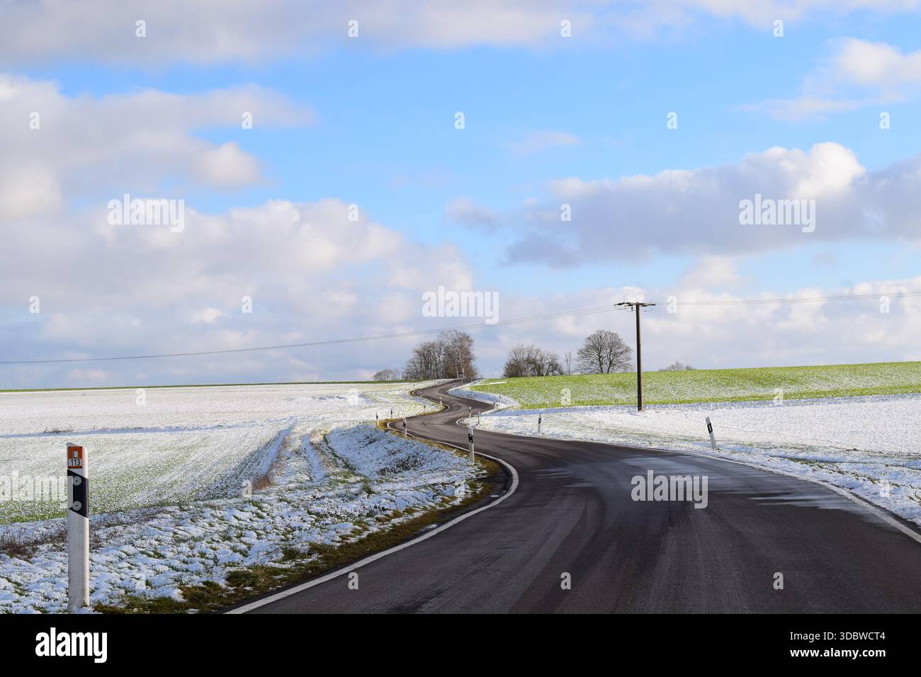 Kurvige Straße durch die schneebedeckte Landschaft Stockfoto