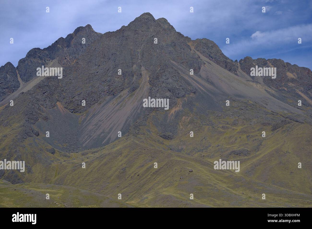 Steile Andenhänge in Peru mit dunklem Geröll, zerklüfteten Felswänden und karger alpiner Vegetation unter einem klaren Hochlandhimmel. Stockfoto