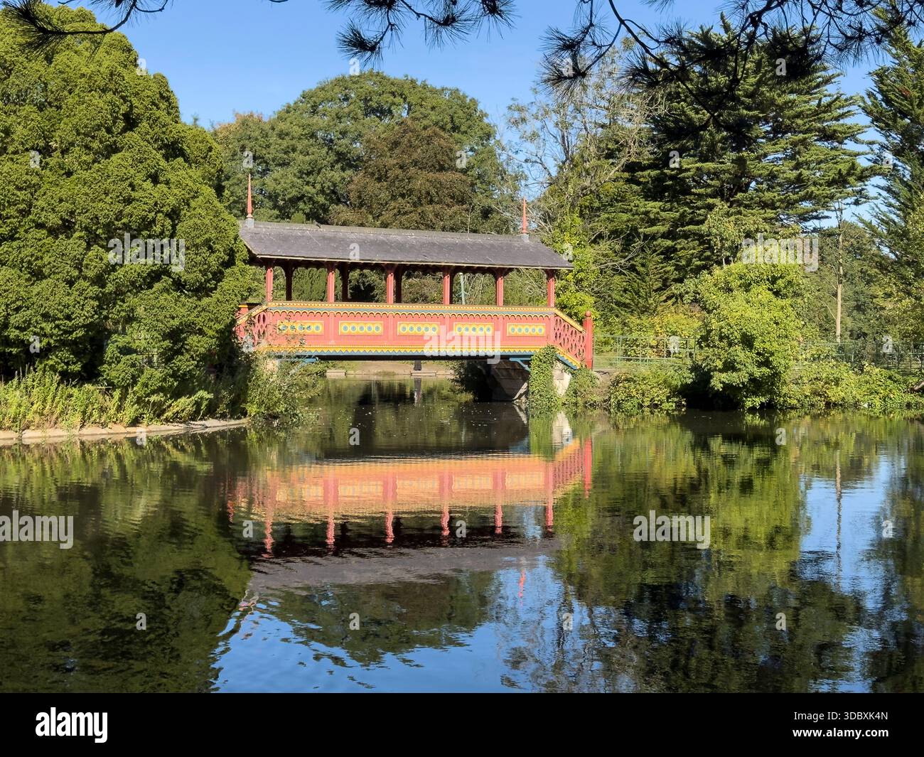 WIRRAL, MERSEYSIDE, ENGLAND - 22. SEPTEMBER 2025: Die Schweizer Brücke überquert das Wasser im historischen Birkenhead Park, Wirral, England - Smartphone-aufgenommenes Stockfoto