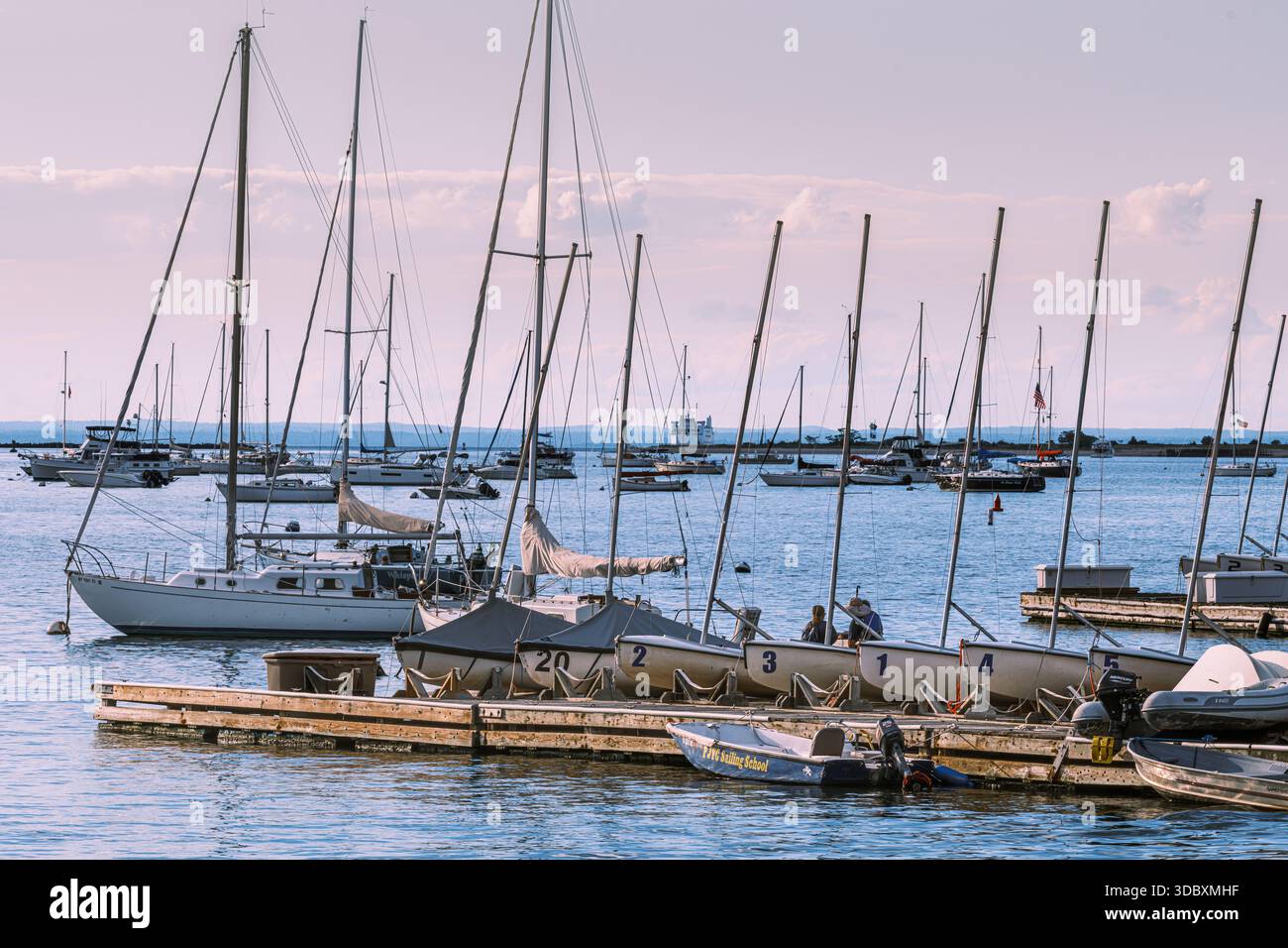 Segelboote, die an einem Yachthafen in Port Jefferson Harbor, Suffolk County, New York, ankern, die alltägliche Freizeitboote entlang der Küste von Long Island zeigen. Stockfoto