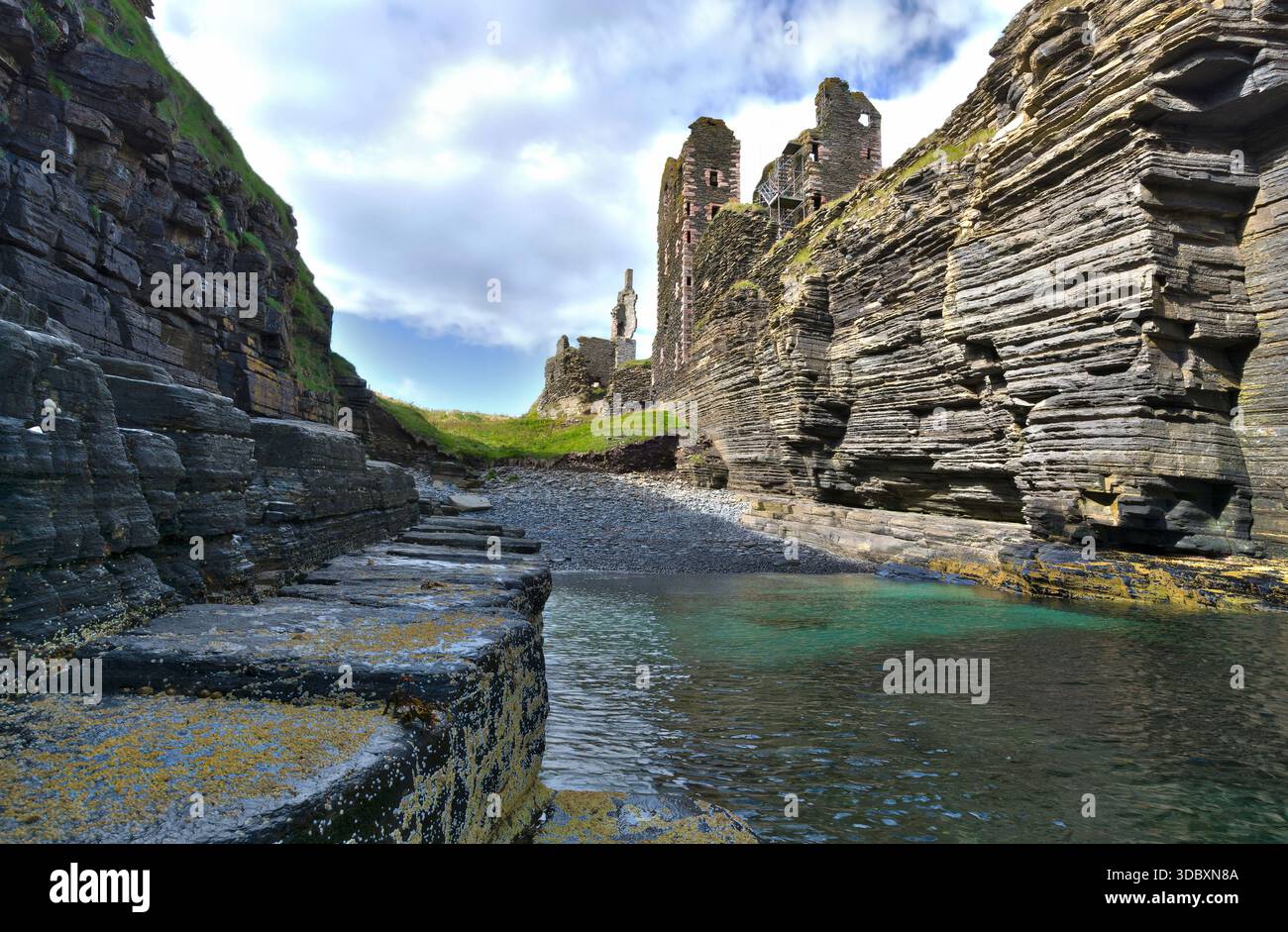 Zerklüfteter Hafen neben den Ruinen der Burg Girnigoe, Sinclair, Caithness, mit türkisfarbenem Wasser und dramatischen Klippen. Stockfoto