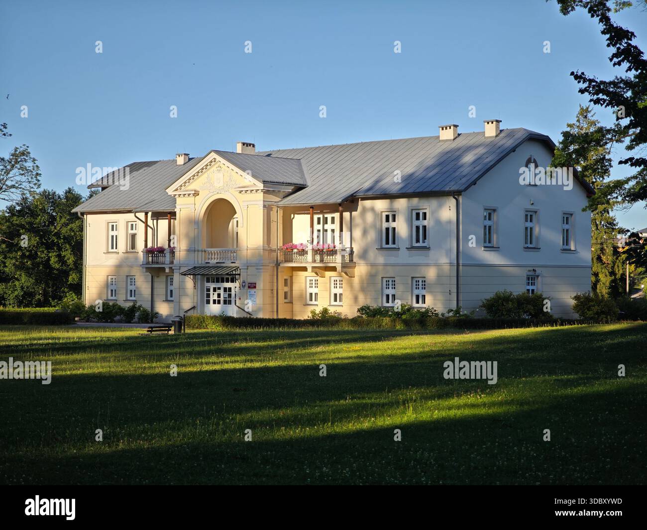 Elegantes Herrenhaus aus dem frühen 20. Jahrhundert in Lipinki, Polen, 1909 erbaut mit neoklassizistischer Fassade, Giebel und blumengeschmücktem Balkon. Stockfoto