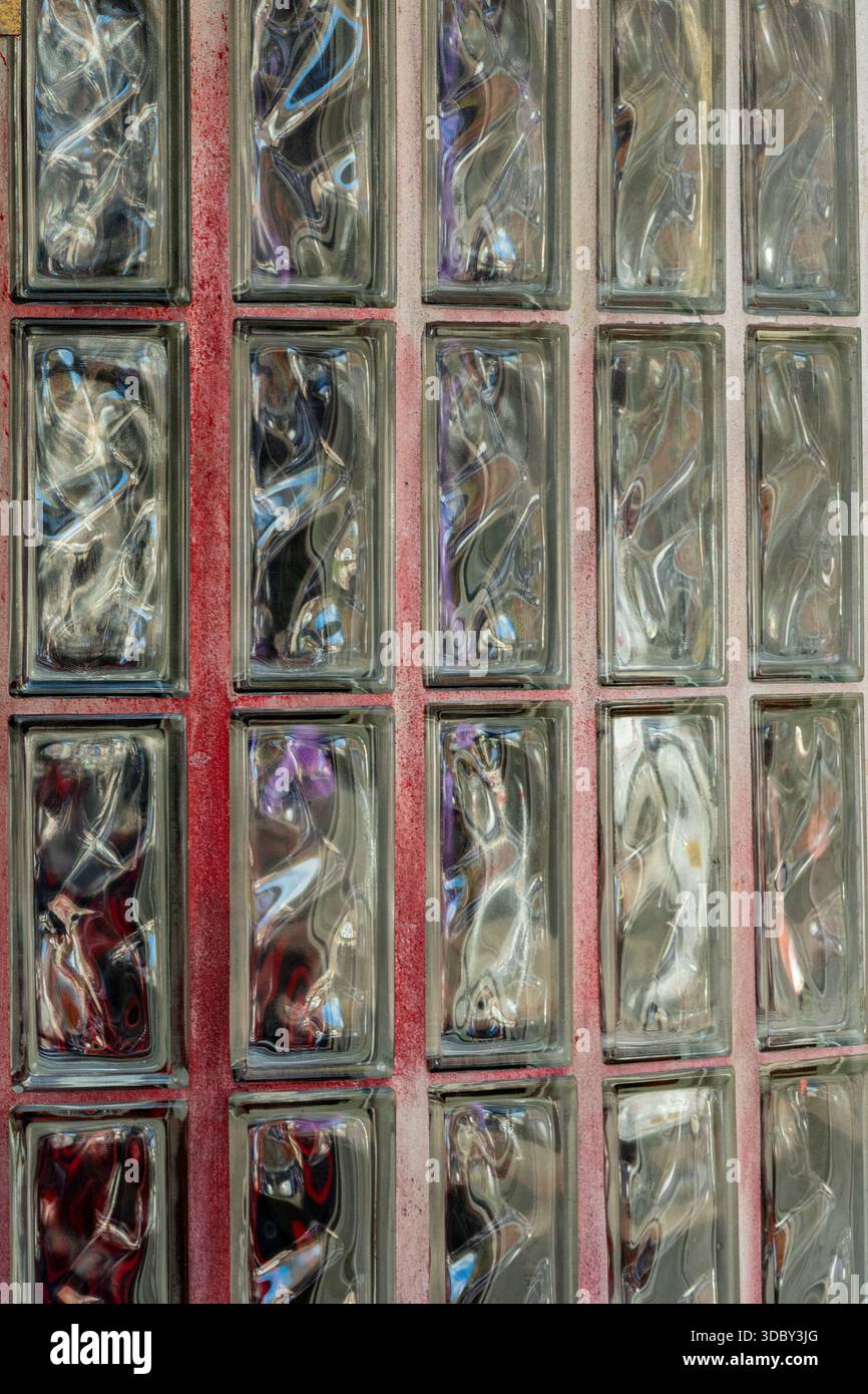 Abstrakt aus Glasziegeln in einer durchscheinenden Wand oder Trennwand, Glasziegelblöcke, die eine abstrakte Wand bilden, geeignet als Hintergrund oder Hintergrund. Stockfoto