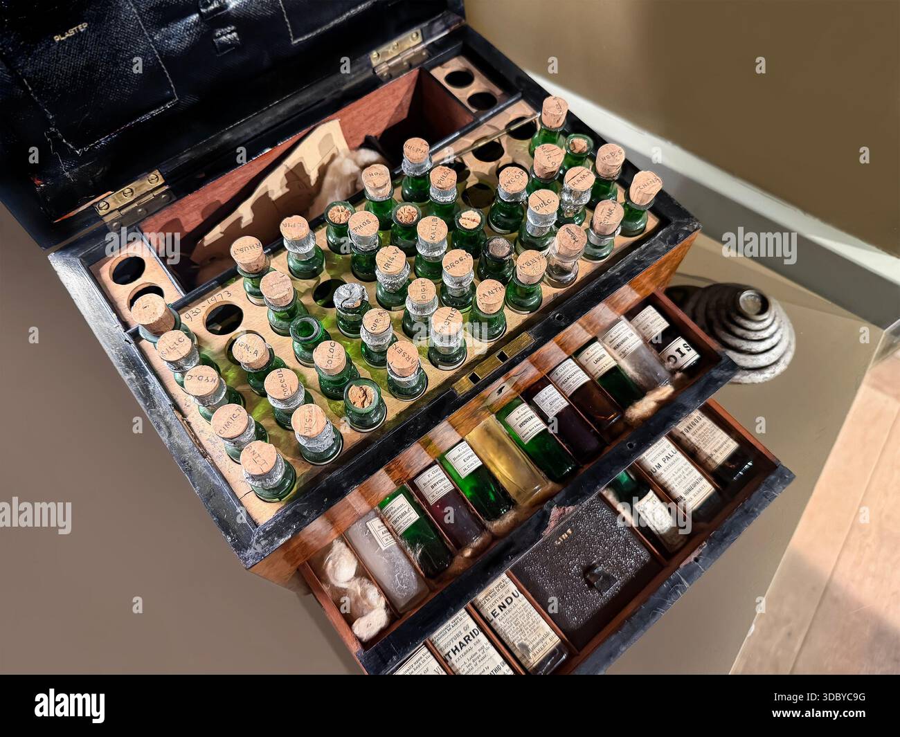 Vintage hölzerne Apothekenkoffer mit mehreren Glasflaschen, Korkstopfen und beschrifteten Fläschchen mit historischen medizinischen Substanzen Stockfoto