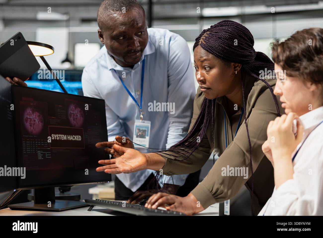 Ingenieurteam im Büro arbeitet zusammen, um Hackerversuche im Unternehmensnetzwerk zu beheben. Teamkollegen aus der IT-Abteilung, die Brainstorming durchführen und Warnmeldungen wegen unbefugten Zugriffs untersuchen Stockfoto