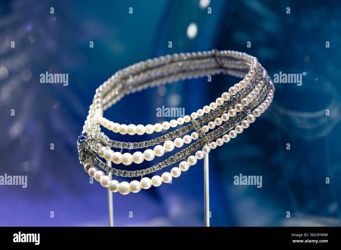 Elegante Halskette mit Perlen und Diamanten auf blauem Hintergrund Stockfoto