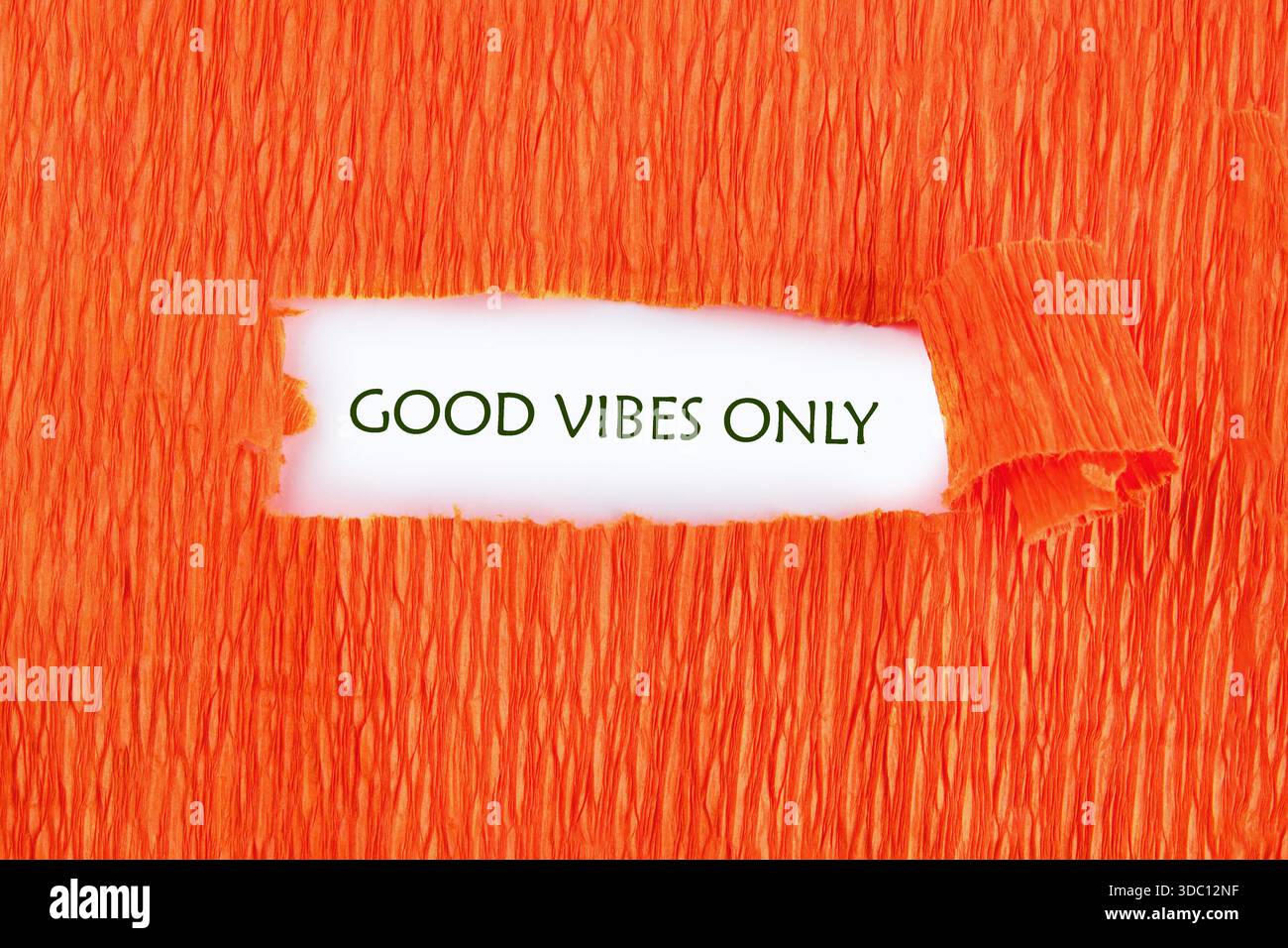 Gerissenes, mandarinenfarbenes Papier zeigt kunstvoll den Ausdruck GOOD VIBES. Es deutet auf eine Stimmung des Glücks, der Inspiration und des optimistischen Gefühls hin Stockfoto