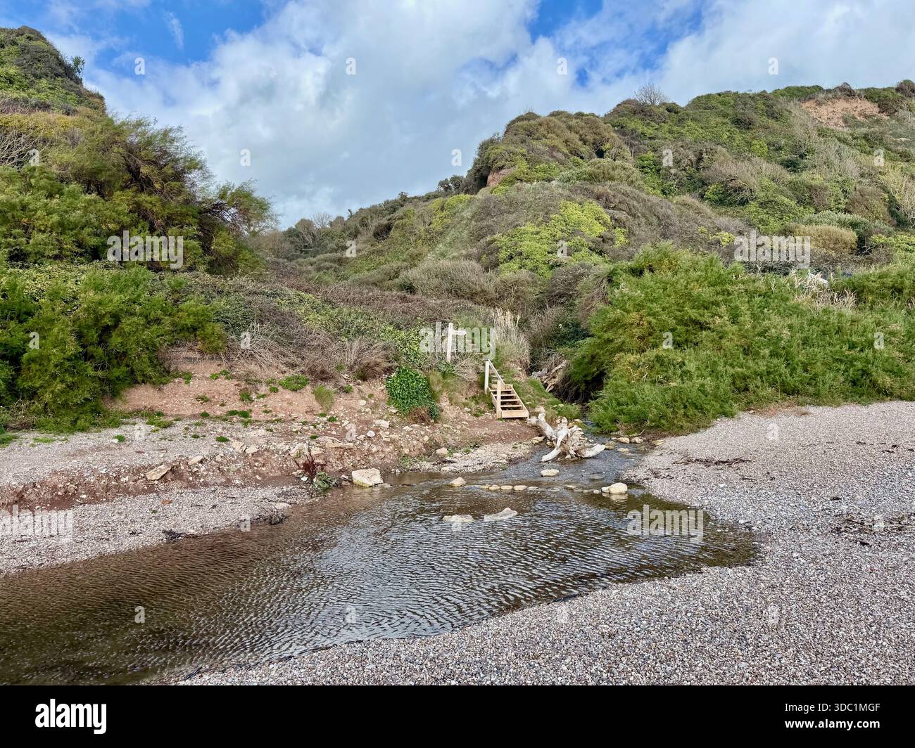 Bachüberquerung und hölzerne Fußgängerbrücke bei Weston Mouth, East Devon, wo der Pfad auf den Kiesstrand unterhalb der Klippen trifft. - Smartphone-aufgenommenes Stockfoto