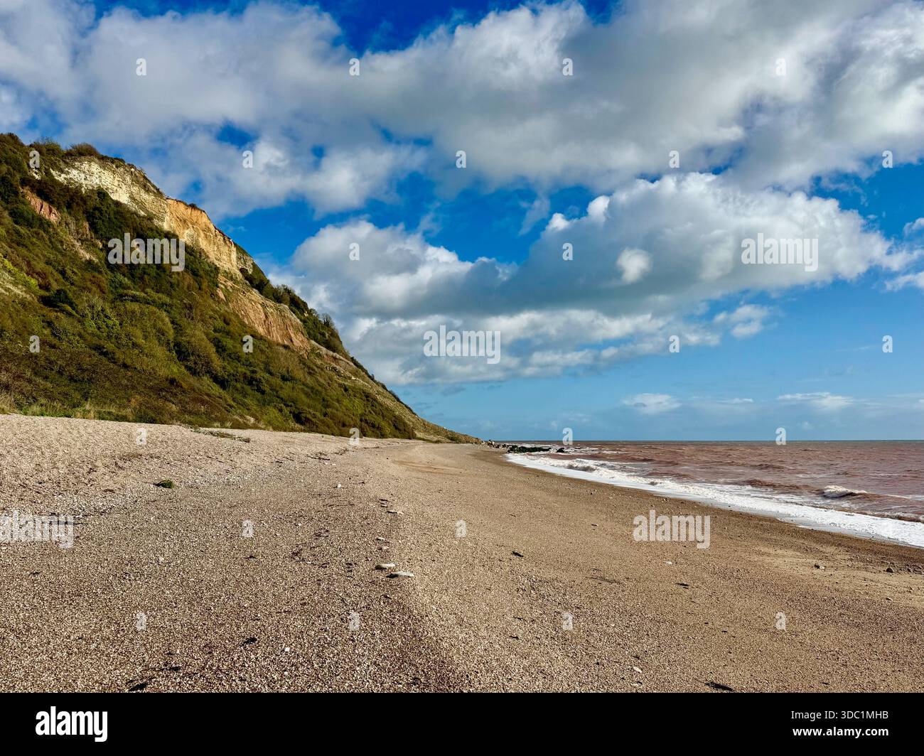 Breiter Kieselstrand in Weston Mouth, East Devon, mit Klippen, die sich am Ufer der Jurassic Coast erheben. - Smartphone-aufgenommenes Stockfoto
