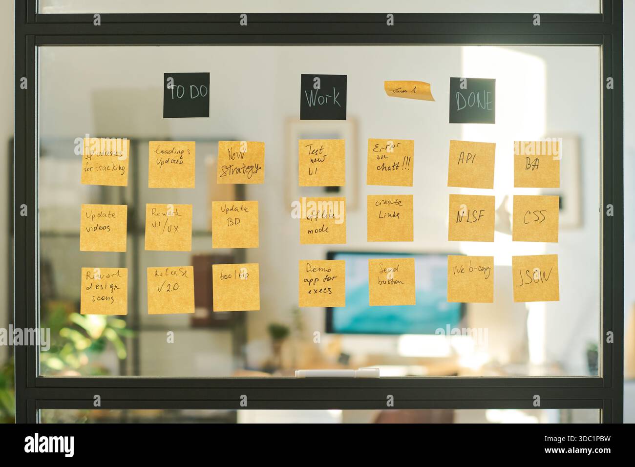 Die Glaswand ist mit Haftnotizen bedeckt, die Säulen „To Do“, „Work“ und „Done“ zeigen, die Projektaufgaben und den Workflow in modernen Büros organisieren und die Verwendung von agilen oder Scrum-Methoden widerspiegeln Stockfoto