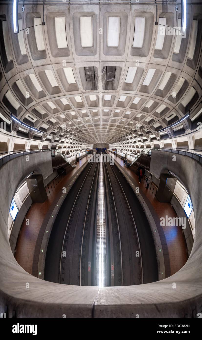 U-Bahn-Station Crystal City Arlington Virginia | ARLINGTON, Va. — Ein Panoramablick auf die U-Bahn-Station Crystal City zeigt die Länge ihres gewölbten Betonhohlkasten-Dachbogens, der sich über die Bahnsteige in Arlington, Virginia, krümmt, am Mittwoch, den 17. Dezember 2025. Die Station bedient den Bezirk Crystal City in Arlington County, einem Teil des Gebiets, das nach Amazons Ankündigung des Hauptsitzes 2018 in National Landing umbenannt wurde. Architekt Harry Weese entwarf die markanten brutalistischen Stationen der Washingtoner U-Bahn, und diese Haltestelle wurde am 1. Juli 1977 auf den blauen und gelben Linien der Washington Metropolitan Area Transit Auth eröffnet Stockfoto