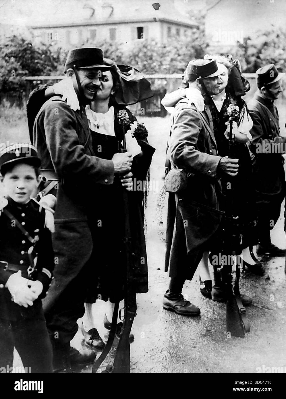 Französische Eisenbahn feiert hundertjähriges Jubiläum -- Alsaoianische Mädchen grüßen französische Soldaten in Uniformen von 1914, während des Wiederaufbaus des Eingangs von Stockfoto