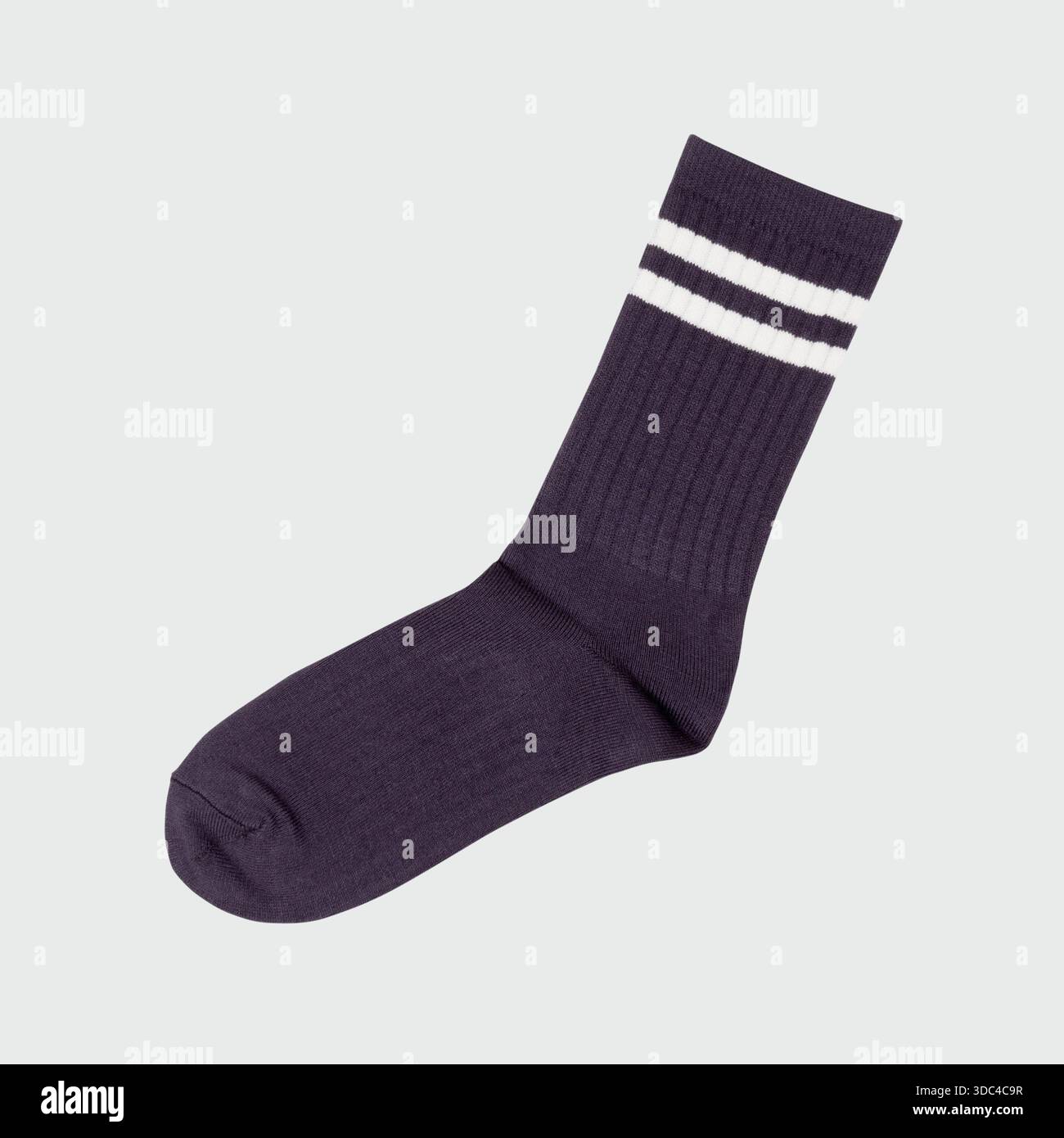 Marineblaue Socke mit weißen Streifen auf hellem Hintergrund Stockfoto