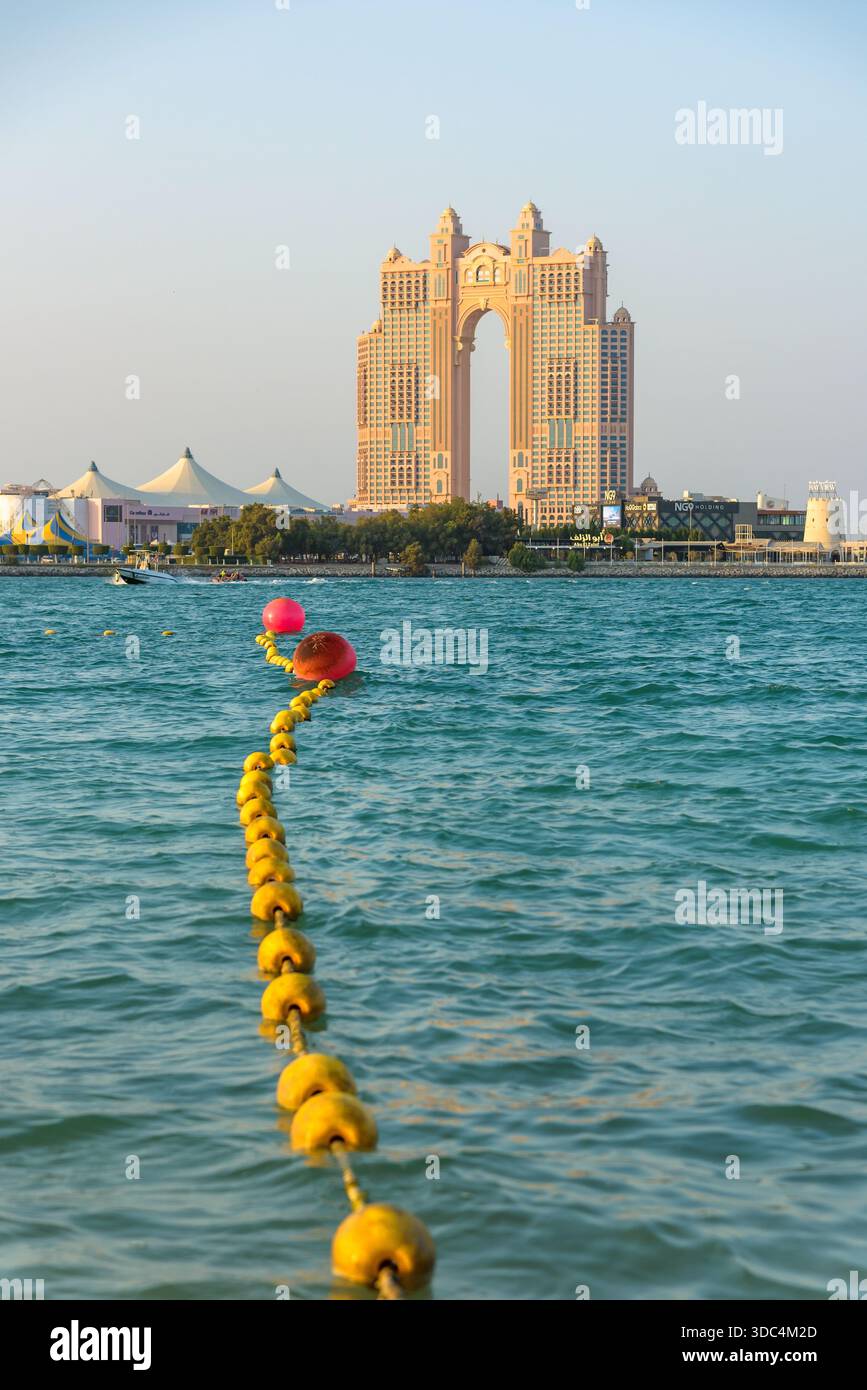 Abu Dhabi, VAE - 24. November 2025: Die majestätische Architektur des Rixos Marina Hotels dominiert den Horizont und strahlt in warmen Licht Stockfoto