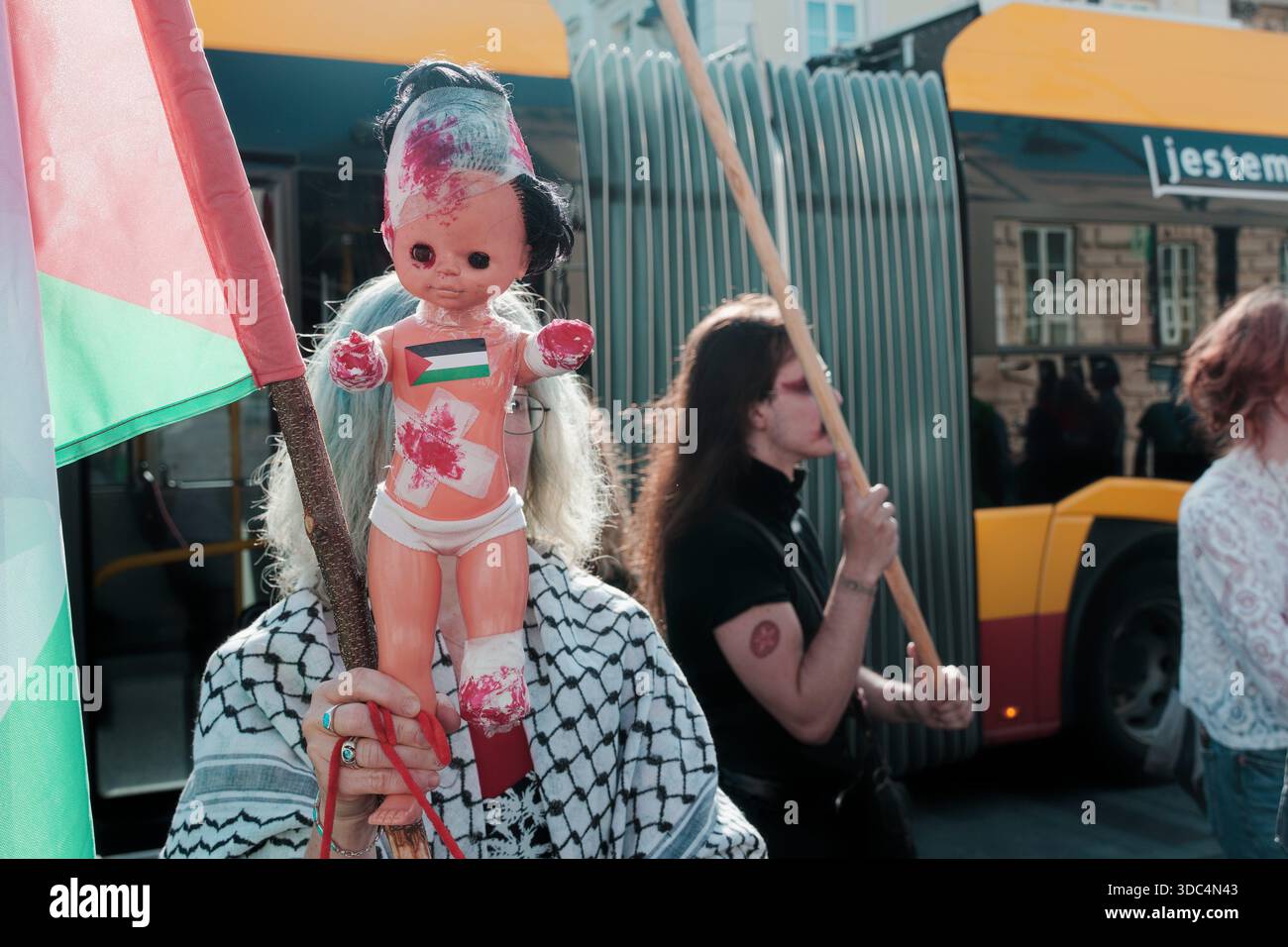 Symbolische Protestpuppe mit palästinensischer Flagge während einer propalästinensischen Demonstration in Warschau, die das Leid der Zivilbevölkerung hervorhebt. Stockfoto