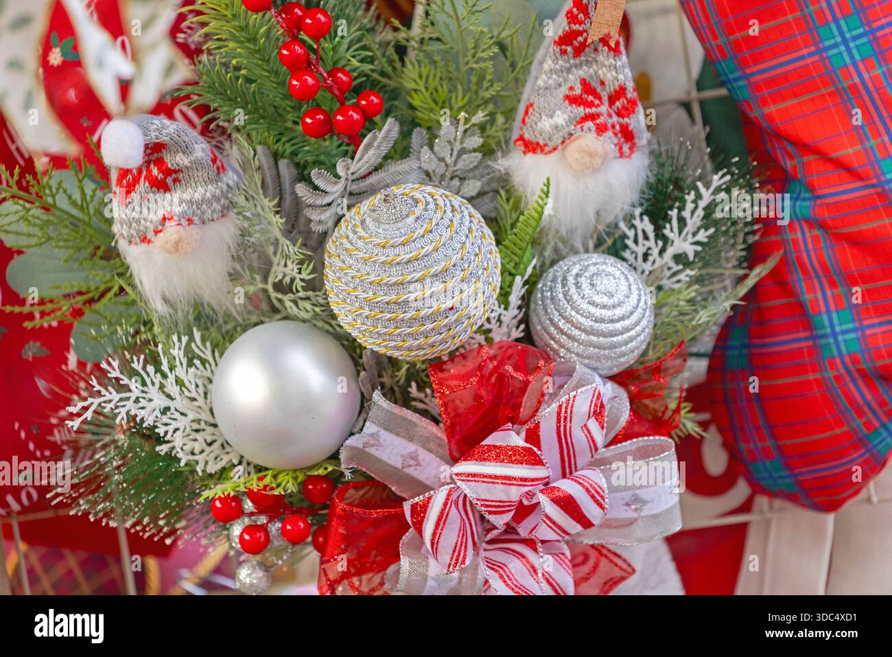 Silberne Kugeln mit Strickspielzeug und Bögen Winterfestdekoration Stockfoto