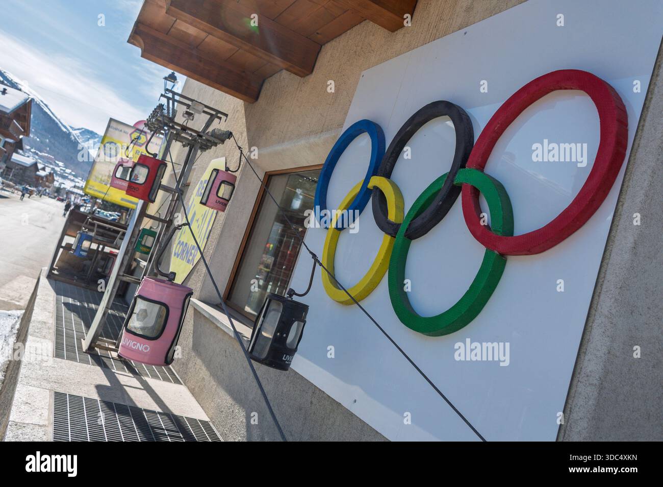 Das olympische Symbol, fünf ineinander verwobene Ringe und ein Minilift auf der Straße in Livigno in der Nähe des Skiverleihs. Milano Cortina Olympische Spiele 2026 Stockfoto