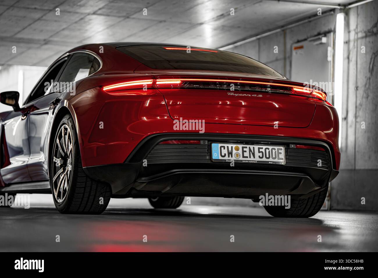 Rotes Auto in einer unterirdischen Garage, moderne Beleuchtung, sportliches Heck, Porsche Taycan, Deer Carsharing, Calw, Deutschland Stockfoto