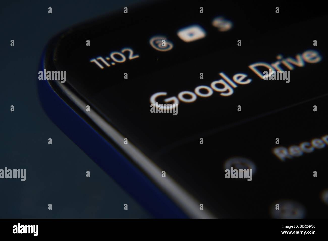Die Google Drive-Oberfläche wird deutlich auf dem dunklen Bildschirm eines Smartphones angezeigt Stockfoto