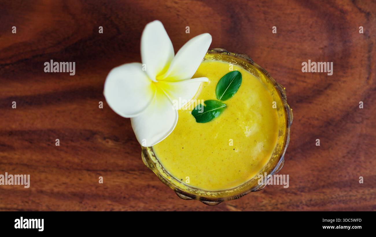 Ubtan- oder ayurvedisches Körperpeeling zur Hautpflege in einer Schüssel auf hölzernem Hintergrund. Traditionelle handgemachte Schönheitsbehandlung mit haldi, Milch, Rosenwasser platziert Stockfoto
