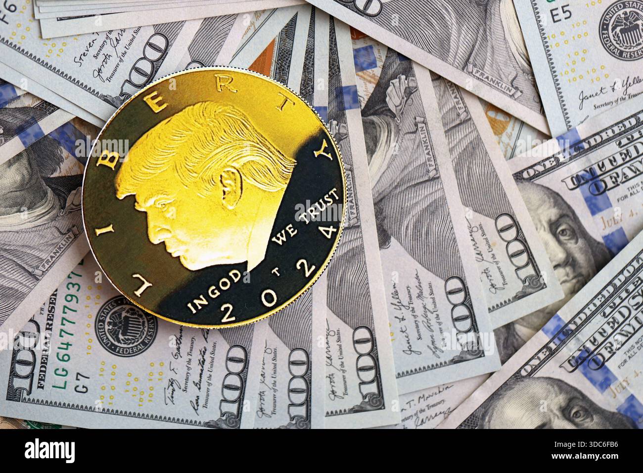 KIEW, UKRAINE - 13. DEZEMBER 2025 Trump Goldmünze auf großen Mengen von US-Dollar-Banknoten Stockfoto