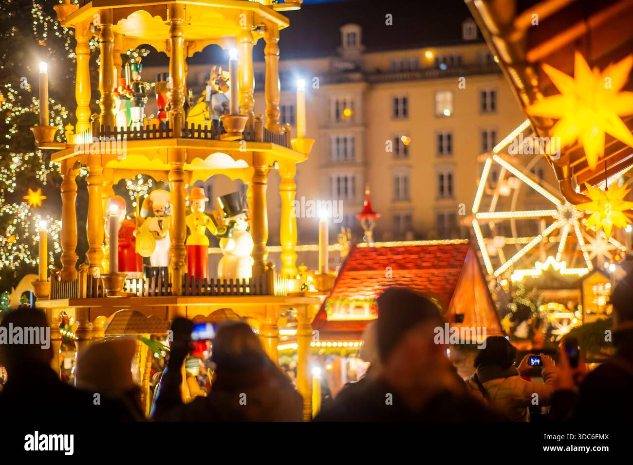 591. Dresdner Striezelmarkt der Dresdner Striezelmarkt iwird seit 1434 im Advent meistens auf dem Altmarkt veranstaltet und zieht jährlich durchschnittlich rund zwei Millionen Besucher an. Er ist der älteste, mit einer Urkunde bestätigte Weihnachtsmarkt Deutschland. Die European Excellent Christmas Market Association EECMA hat den Dresdner Striezelmarkt 2025 als exzellenter europäischer Weihnachtsmarkt ausgezeichnet. Touristen machen Handyfotos. Dresden Sachsen Deutschland *** 591 Dresden Striezelmarkt der Dresdner Striezelmarkt findet seit 1434 statt, meist im Adventsalter auf dem Altmarkt, und Stockfoto