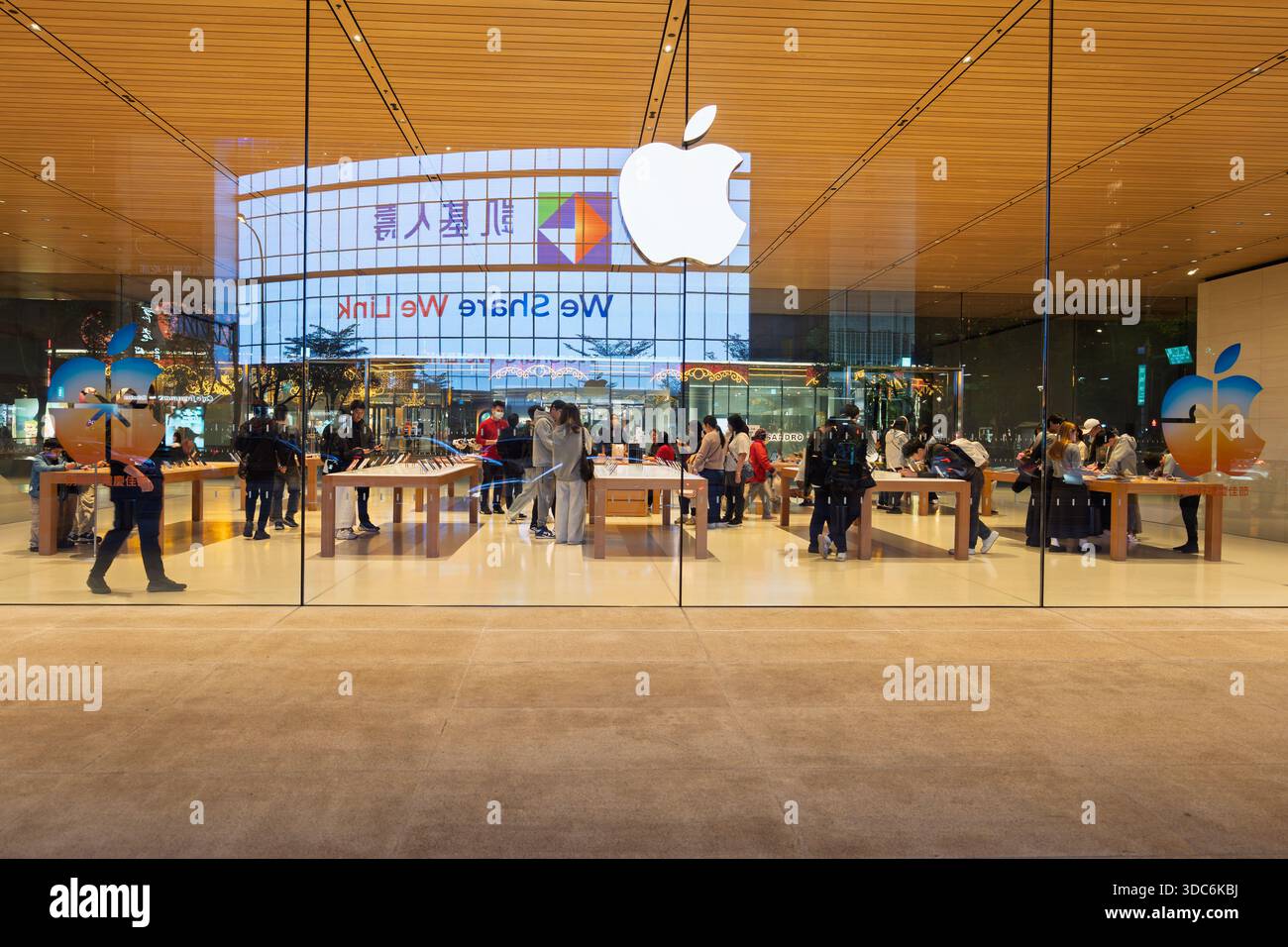 Taipei, Taiwan - 20. Dezember 2025: Innenansicht des Apple Store durch Glasfassade, bei der Kunden Produkte suchen Stockfoto