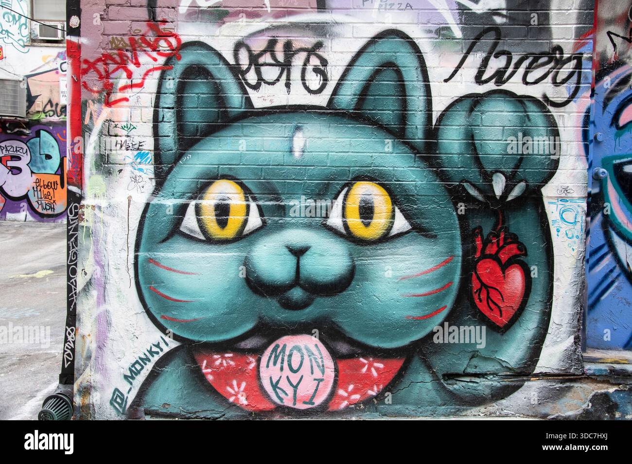 Maneki-neko-schwebendes Katzengemälde im Modeviertel Graffiti Alley in der Innenstadt von Toronto, Ontario, Kanada Stockfoto
