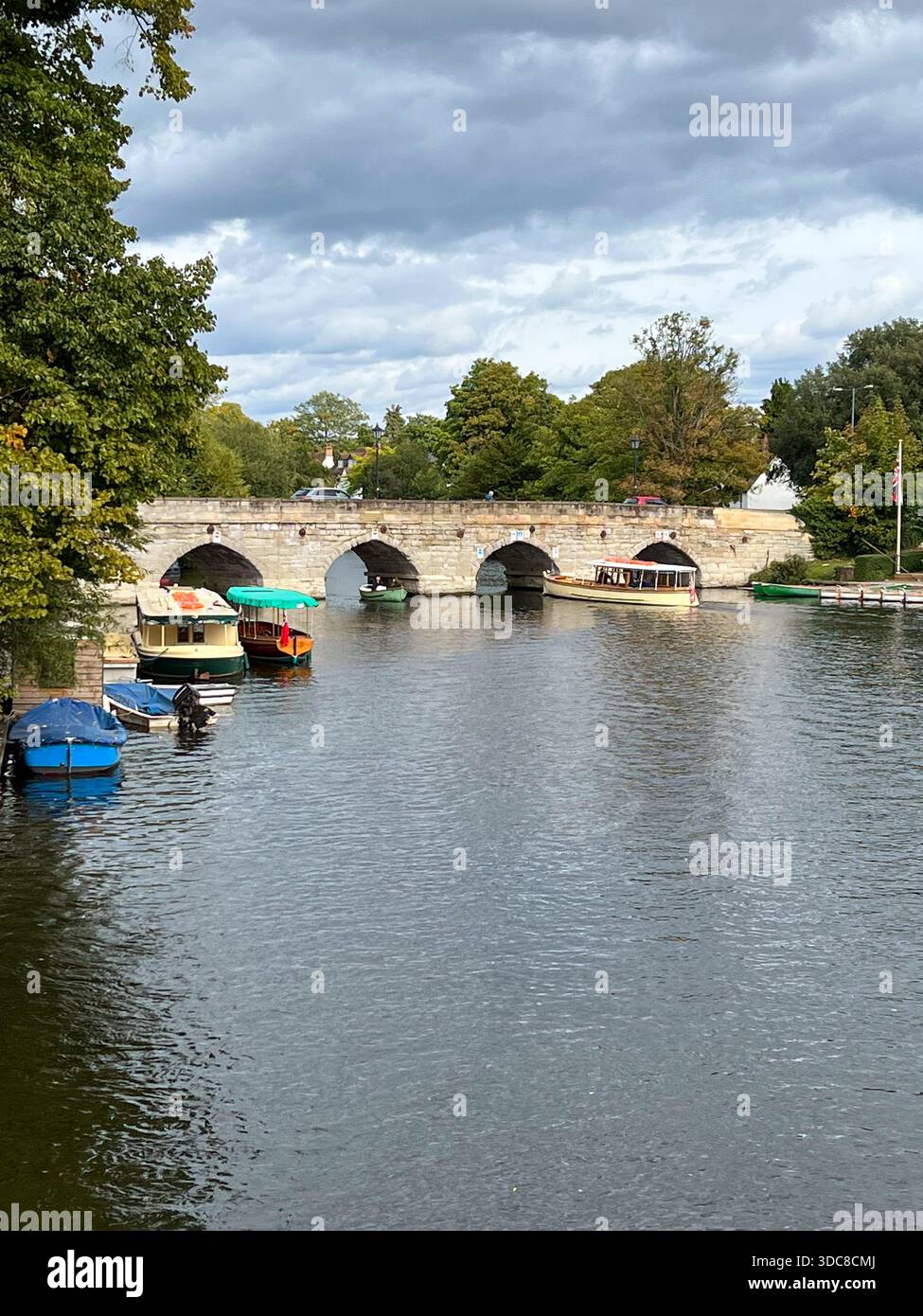 Stone Arch Bridge mit vertäuten Booten auf dem Calm River, England - Smartphone-aufgenommenes Stockfoto