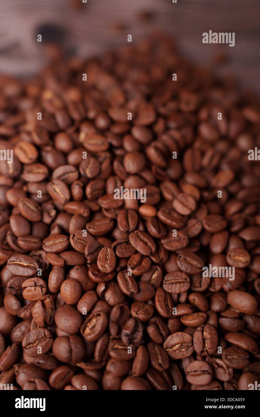 Nahaufnahme gerösteter Kaffeebohnen mit satten Brauntönen, die Textur und Details betonen und eine warme, erdige, aromatische Atmosphäre mit einem Sinn erzeugen Stockfoto