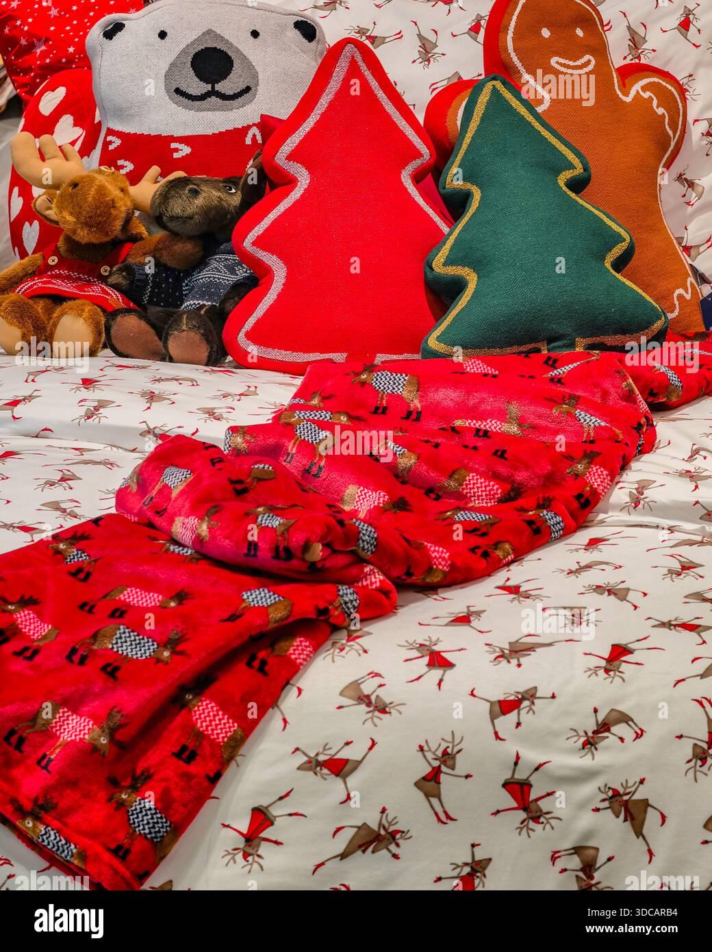 Weihnachtsbettwäsche und festliche Feiertagskissen mit Rentier-Muster für gemütliche saisonale Schlafzimmer-Dekor festliche Feierlichkeiten Hintergrund Happy New Year Stockfoto