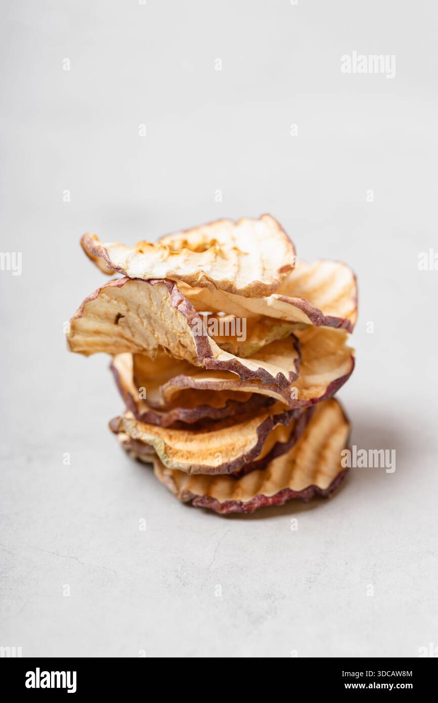 Apfelscheiben auf hellgrauem Hintergrund. Ein gesunder und köstlicher Snack voller Vitamine. Geeignet für Vegetarier. Stockfoto