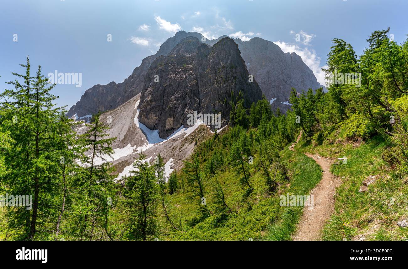 Eine ruhige Bergwanderung offenbart unberührte alpine Schönheit mit üppigem Grün, zerklüfteten Gipfeln und einem ruhigen Pfad, der durch Sloweniens atemberaubendes SOC führt Stockfoto