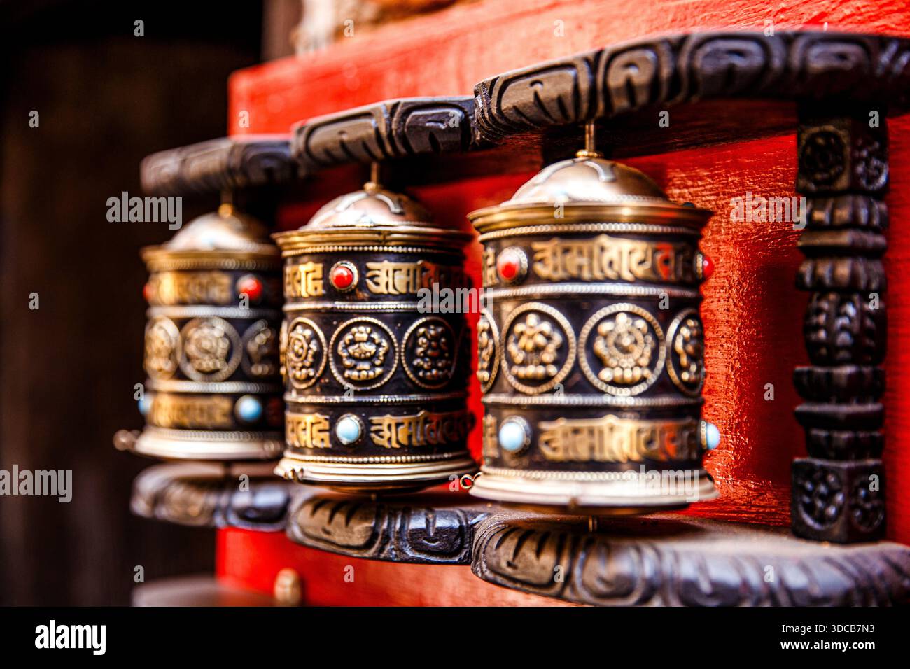 Nahaufnahme traditioneller buddhistischer Gebetsmühle mit geschnitzten Metalldetails in einem Tempel in Nepal. Stockfoto