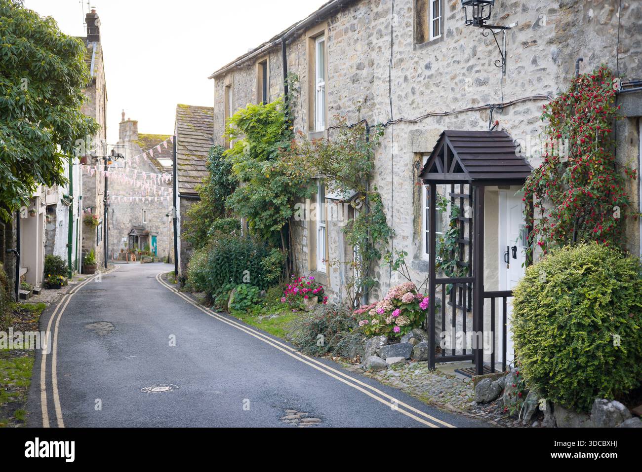 Friedliche Dorfstraße gesäumt von traditionellen Steinhäusern, Grassington, Wharfedale, Yorkshire Dales, Großbritannien Stockfoto