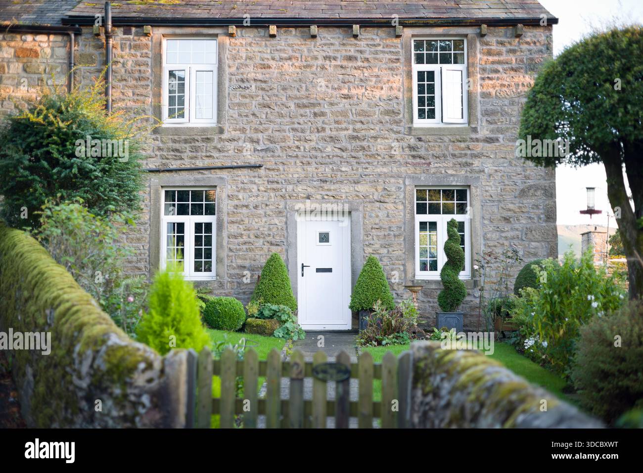 Steinhaus in Grassington, Yorkshire Dales, Großbritannien, mit Holzfenstern und Haustür und Vorgarten mit Tor Stockfoto