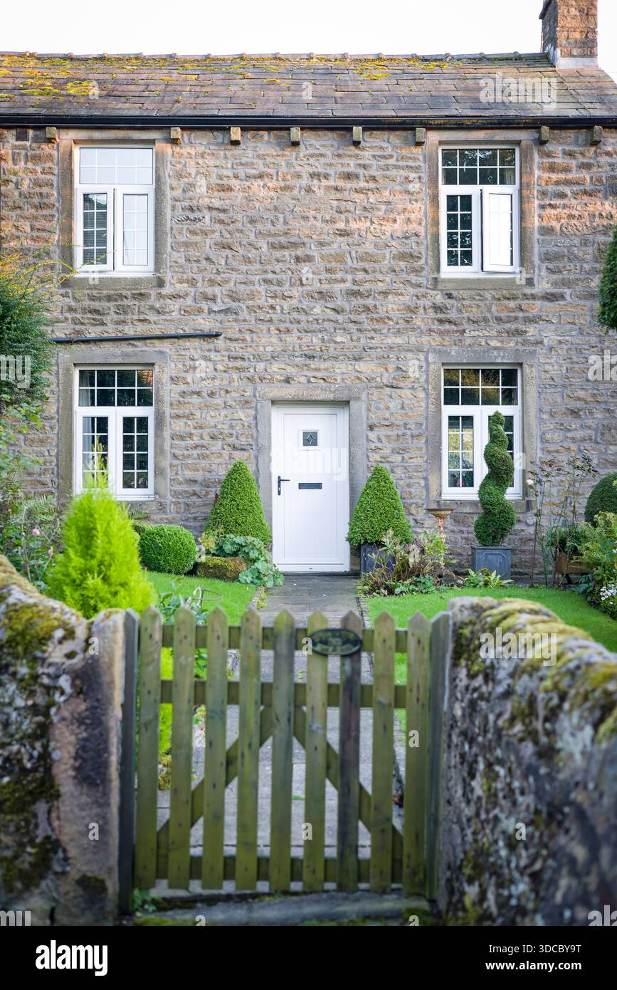 Steinhaus in Grassington, Yorkshire Dales, Großbritannien, mit Holzfenstern und Haustür und Vorgarten mit Tor Stockfoto